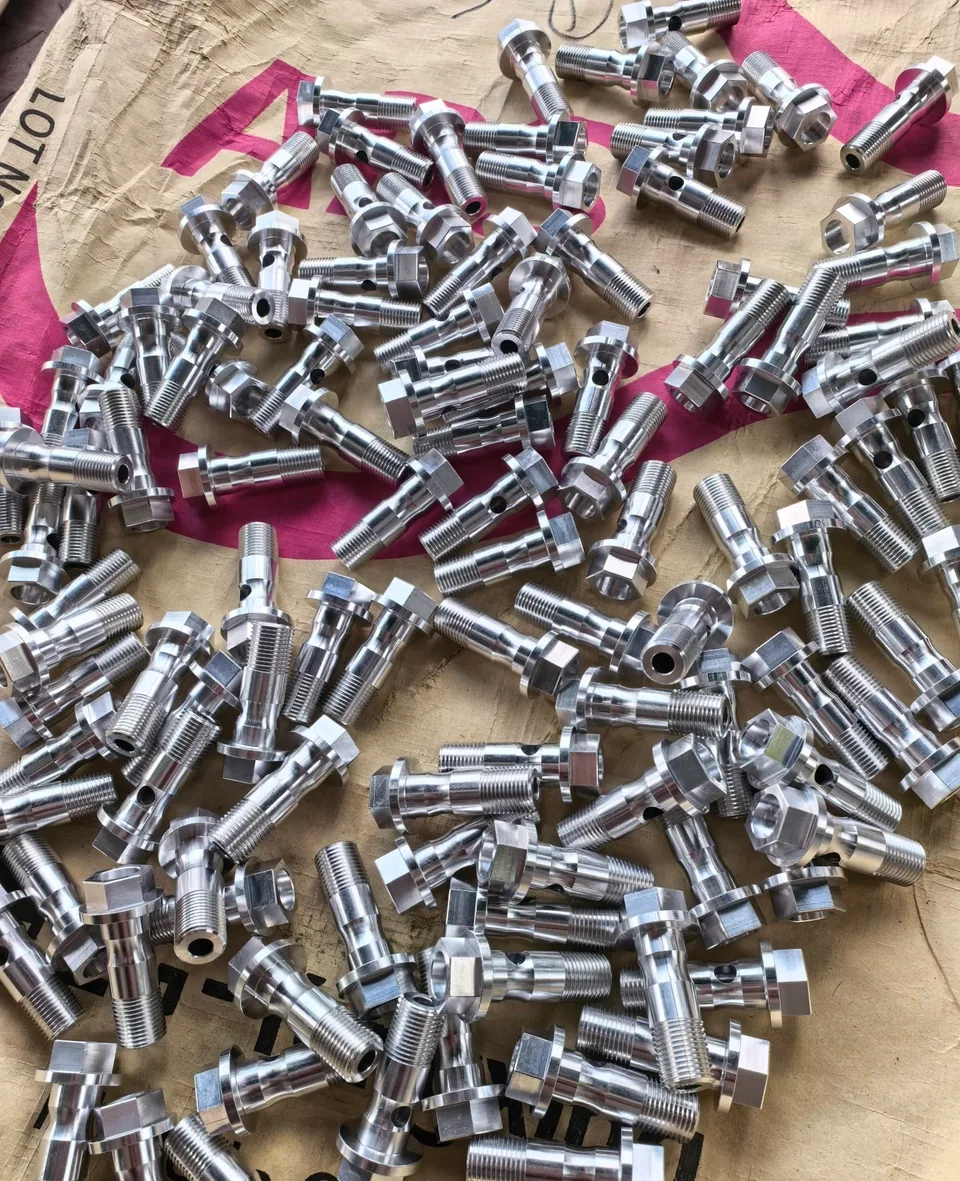 Reference photograph of aluminum parts with wrench flats and cross-holes