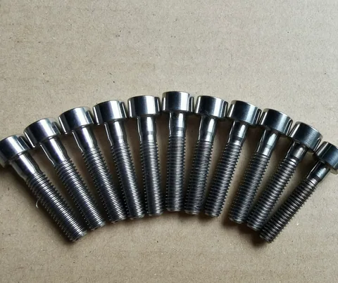 A row of socket-head bolts showing cylindrical heads, shoulders and threaded shanks