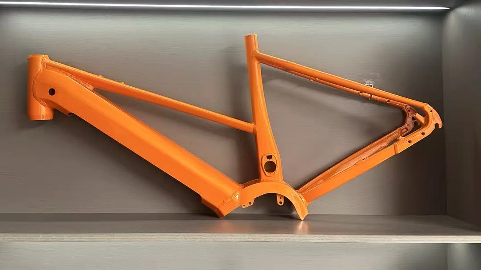 Existing orange frame reference with rigid rear triangle, seat tube, dropout and external mounting regions