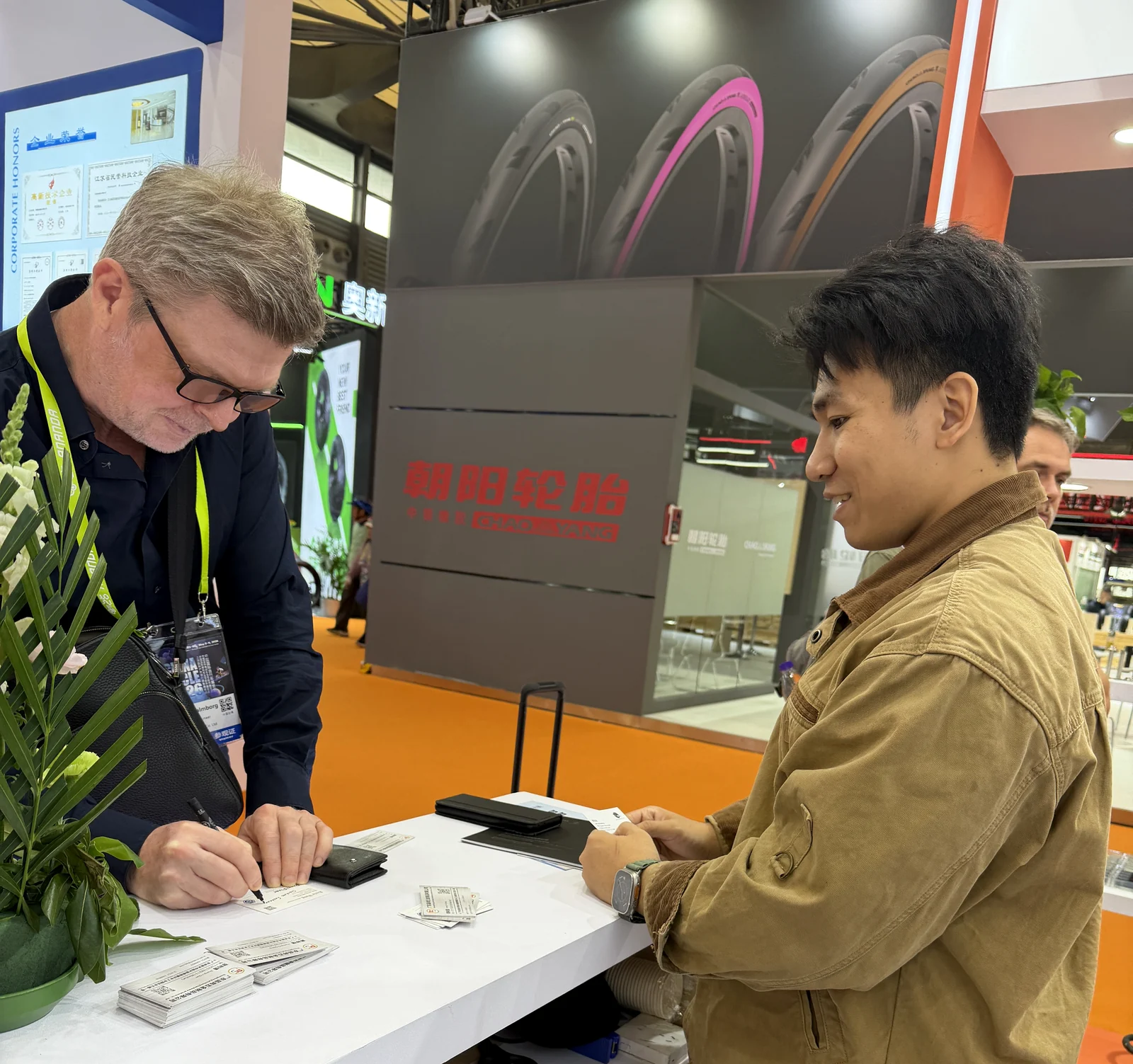 Trade show visitor exchanging contact information after a technical discussion