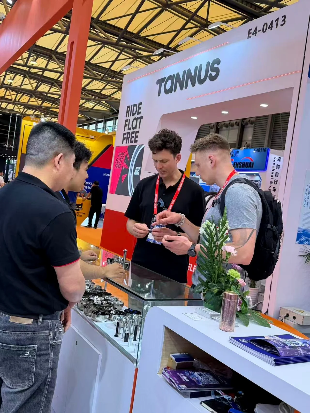 PremFixer staff discussing bicycle fastener samples with international visitors