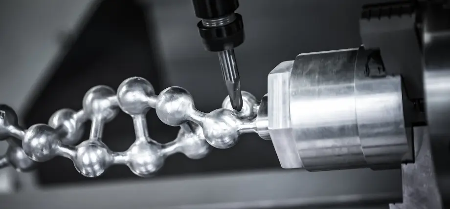 CNC mill precisely shaping a metallic molecular chain model