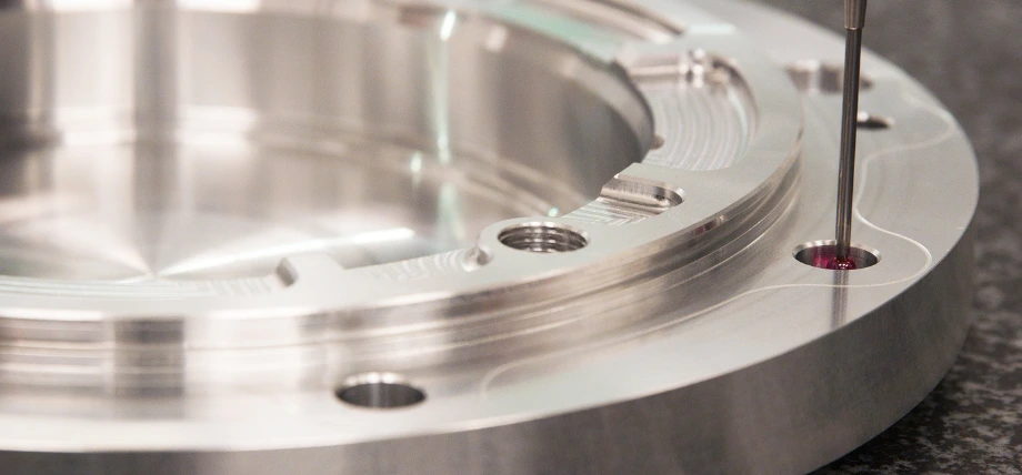 CMM probe inspecting a machined aluminum component